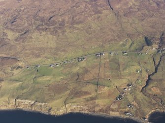 Oblique aerial view of the remains of the eastern end of Trumpan Mor and the western end of the townships of Upper and Lower Halistra, with the remains of adjacent dykes, enclosures and lazy beds, Waternish, Skye, taken from the SW.