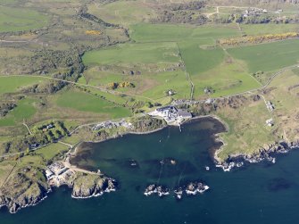 General oblique aerial view of Lagavulin Distillery with the remains of the fort and Dunivaig Castle adjacent, taken from the SSE.