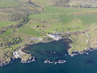 General oblique aerial view of Lagavulin Distillery with the remains of the fort and Dunivaig Castle adjacent, taken from the SSE.