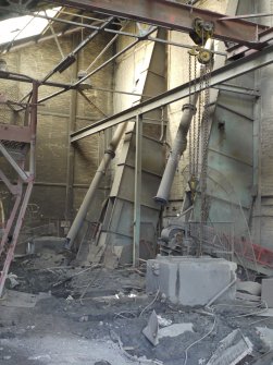 Pan House/ Machine Wing., ground floor. Interior. View from north wast. There were three pan mills on this level. All have been removed prior to demolition. Two of the bucket elevators from the pan mills and supplying the crushed clay hoppers in the adjacent pan house compartment are visible.
