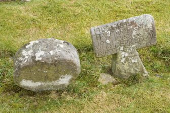Detail of Round headed and T shaped gravestones within the burial ground to the south east of the church