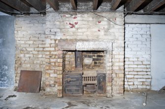 Interior. View of fireplace and range within basement.
