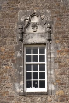Detail of window with carved stone pediment on east gable of south facade
