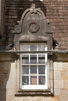 Detail of west dormer window with carved stone pediment at 1st floor level of south facade