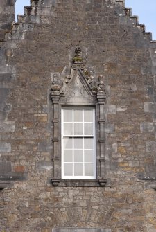 Detail of window with carved stone pediment on south gable of west facade
