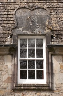 Detail of central dormer window with carved stone pediment at 1st floor level of east facade