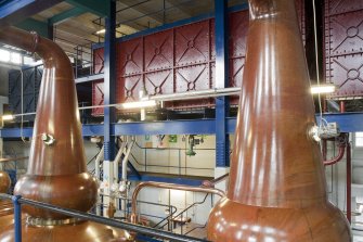 Interior. Still house, view showing storeage tank behind copper stills