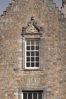 Detail of 2nd floor window with carved stone pediment on north gable of west facade