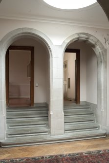 Interior. 2nd floor, corridor, view of double arch and stairs at north end