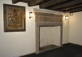 Interior, detail of amorial panel and fireplace, upper ground floor, NE house.
