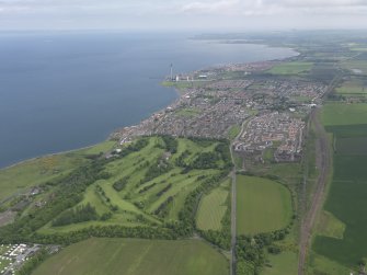 General oblique aerial view of Prestonpans centred on Royal Musselburgh Golf Course, taken from the SSW.