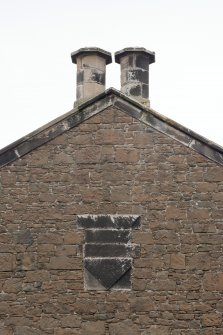 Detail of stone plaque and paired chimney stacks to gablehead of rear, north west elevation.