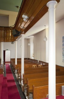 View looking along side aisle of church, showing side gallery and ground floor pews.