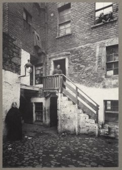 Photograph showing High Riggs, Edinburgh with inhabitants outside. 
Titled: 'High Riggs. Old houses, now demolished. 1904. A H Baird'. 
Edinburgh Photographic Society Survey of Edinburgh and District, Ward XIV George Square