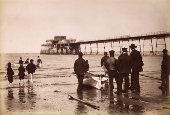 View of men and boat on beach by Portobello pier.
Titled: 'Boating. J P. 135'.
Subtitled in pencil: 'Portobello Blown down after 1918'.
PHOTOGRAPH ALBUM NO.195: PHOTOGRAPHS BY G W WILSON & CO