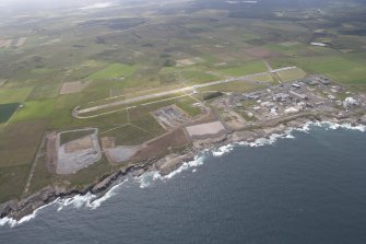 General oblique view of Dounreay Nuclear Power Development Establishment, and the disused airfield, looking to the SE.