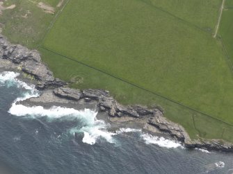 Oblique aerial view of the broch and cairn at Green Tullochs, looking SE.