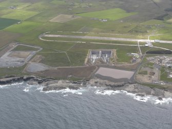 Oblique aerial view of Dounreay Nuclear Development Establishment, centred on the site of the storehouses, looking SE.