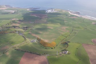 General oblique aerial view of Branxton, Torness Nuclear Generating Station, Skateraw Harbour and Harp Law, looking NE.