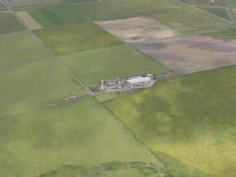 Oblique aerial view centred on the farmstead and graveyard at Holland, Stronsay, looking NE.
