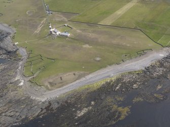 Oblique aerial view centred on the enclosures and lighthouse at Dennis Head, looking SW.