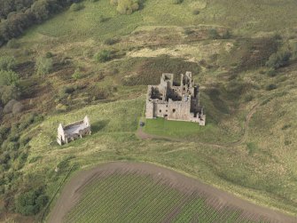 General oblique aerial view of Crichton Castle with The Slaughter House adjacent, looking to the NW.
