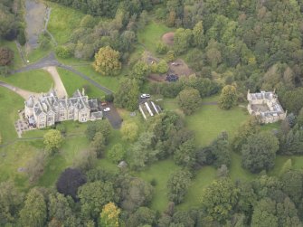 General oblique aerial view of Vogrie House with adjacent stables, looking to the NW.