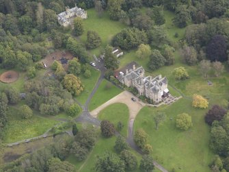 General oblique aerial view of Vogrie House with adjacent stables, looking to the E.