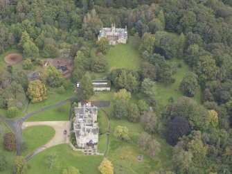 General oblique aerial view of Vogrie House with adjacent stables, looking to the NE.