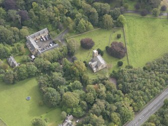 General oblique aerial view of Cranston Parish Church with adjacent churchyard and Oxenfoord Castle stables, looking to the SE.