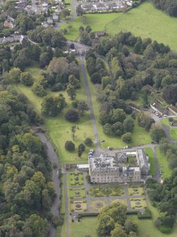 General oblique aerial view of Newbattle Abbey House with North Lodge adjacent, looking to the WSW.