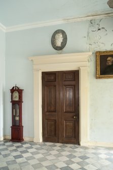 Ground floor. Entrance hall with internal door and wall plaque from west.