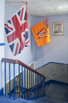 Interior. General view looking down into stairwell from 1st floor including flags.