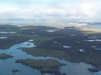 General oblique aerial view of Nibon with Sullom Voe in the distance, looking NE.