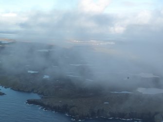 General oblique aerial view of Nibon with Sullom Voe in the distance, looking NE.