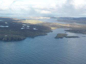 General oblique aerial view of Egilsay with Sullom Voe in the distance, looking NE.