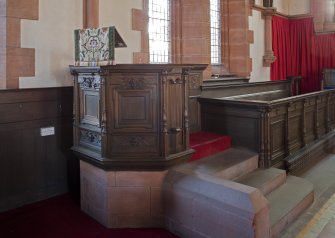 Interior. View of font and choir stalls