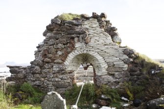 View of internal east wall of chapel with round arched opening to window.