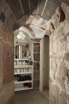 Ground floor. Corridor to east of kitchen, vaulting and carved heads.
