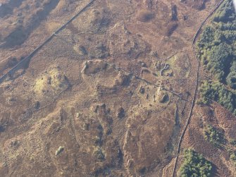 Oblique aerial view of the buildings and field boundaries, looking SW.