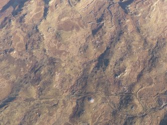 Oblique aerial view of the cairn, enclosures and small cairns, looking NE.