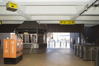 Interior view across the concourse of Govan Cross Subway Station, 771-5 Govan Road, Glasgow, looking towards main entrance, including ticket machines, turnstiles and news booth