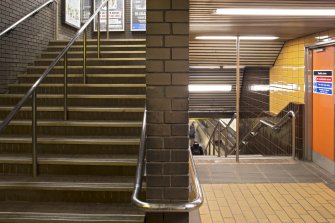 Interior. View square-on to central wall of main stair within Kelvinhall subway station, showing up and down flights