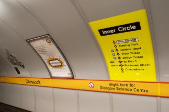 Detail view of signage and network maps on the tunnel wall of Cessnock subway station