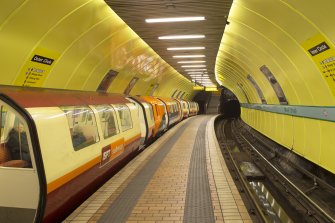 View looking along the island platform and tracks of West Street subway station, with a train waiting at the Outer Circle platform