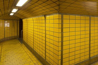 View of tiled corridor linking platform and concourse levels of West Street subway station