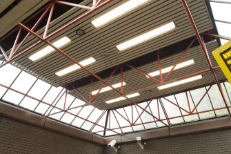 View looking up at the exposed structure and rooflights of the concourse at West Street subway station