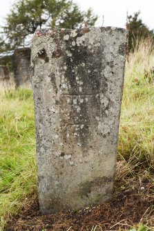 View of cross-incised gravemarker (1) located in graveyard to north of church (daylight)