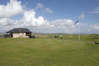 Starter's hut and practice green from west.