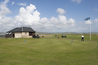 Starter's hut and practice green from west.